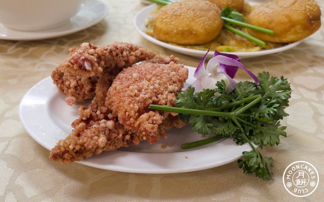 A small plate of red-tinted fried fish fillets accompanied with cilantro and an orchid